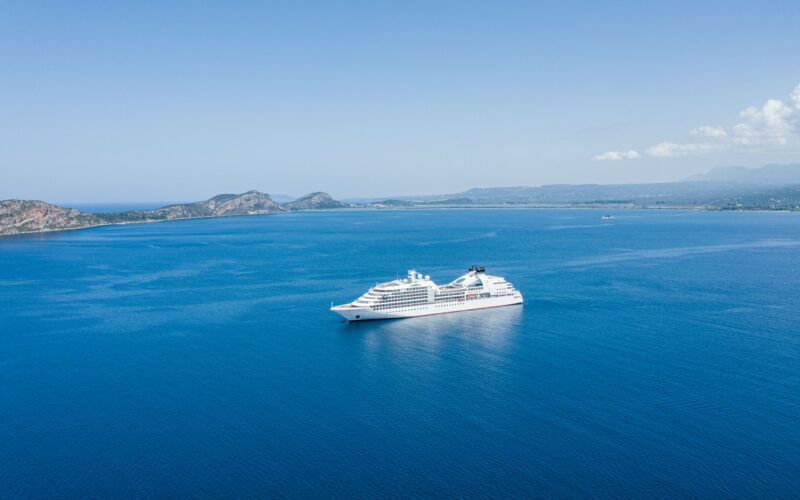 Cruiseschip op een blauwe zee langs de kust