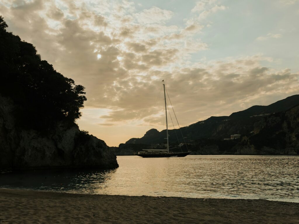 Zeilboot in de baai van Rovinia op Corfu bij zonsondergang
