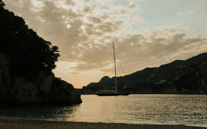 Zeilboot in de baai van Rovinia op Corfu bij zonsondergang