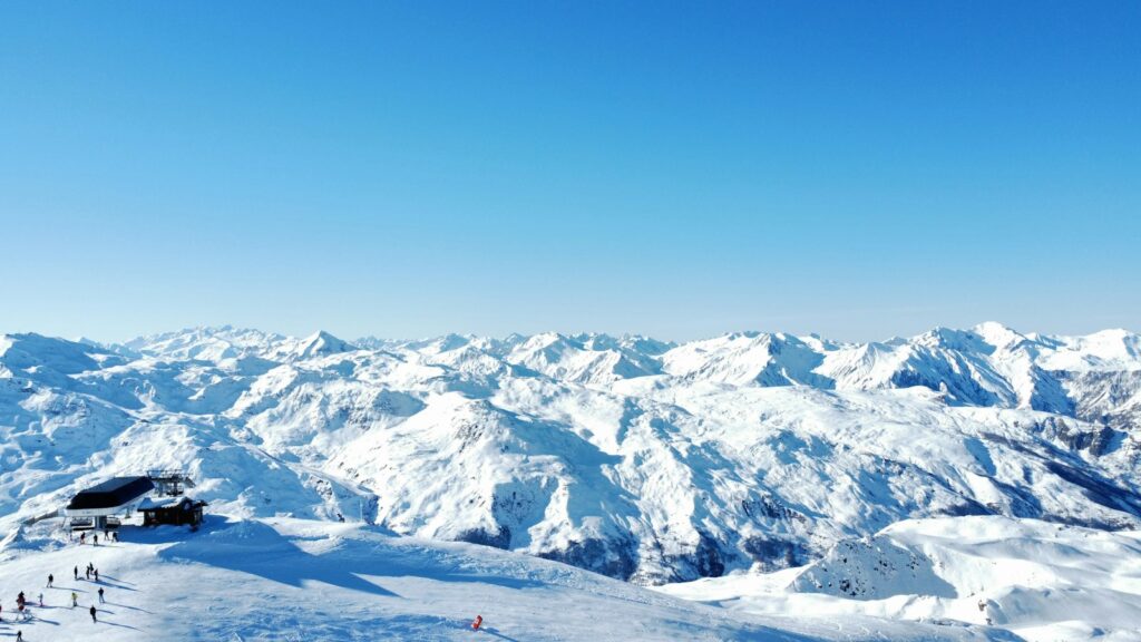 Uitzicht vanaf een skipiste over besneeuwde bergen
